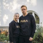 Musta collegepusero kultaisella tekstillä